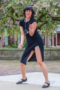 Laurana Wong - Street Dance Party - She raises her hip, bending forward slightly in the dance, a speaker at her heart and her head in blossoms